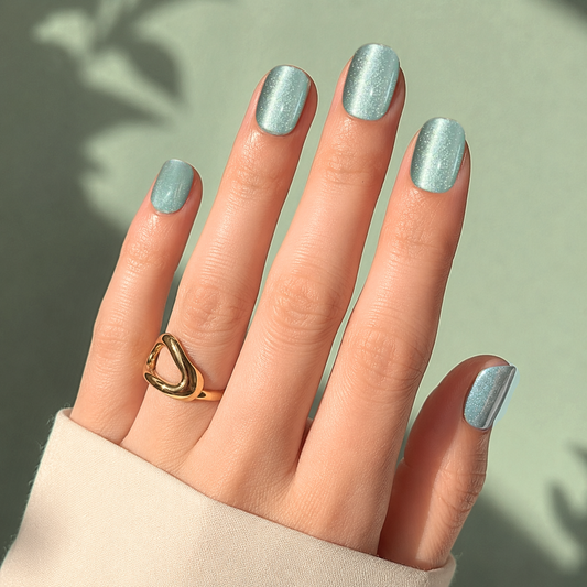 Soft gel press-ons in sage green with shimmering cat's eye finish, short square shape