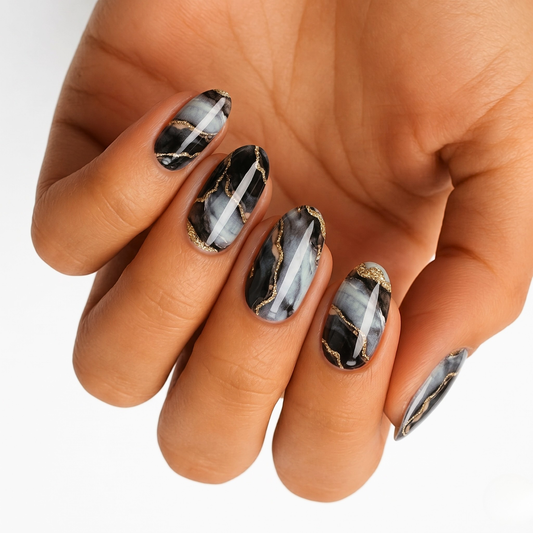 Black and grey marble nail wraps with gold foil crackle veining, glossy finish, almond shape