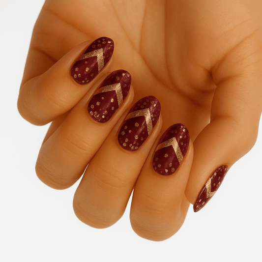 Matte burgundy nail wraps with gold glitter chevron tips and scattered dots