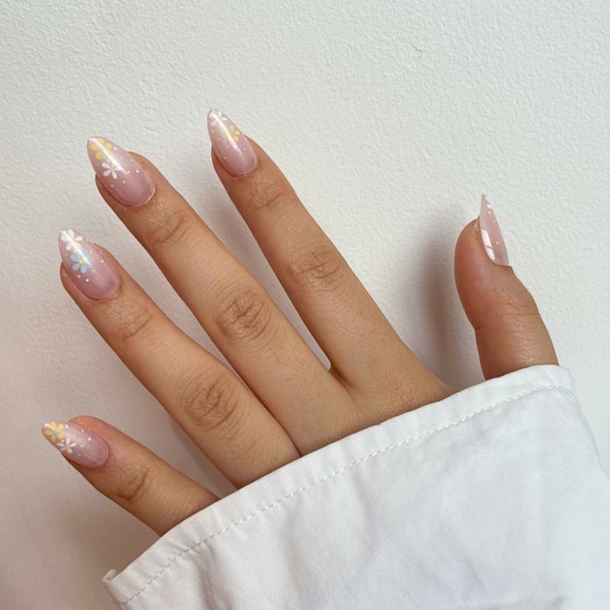 Sheer glossy press-on nails, almond shape, with white daisy florals at the cuticle