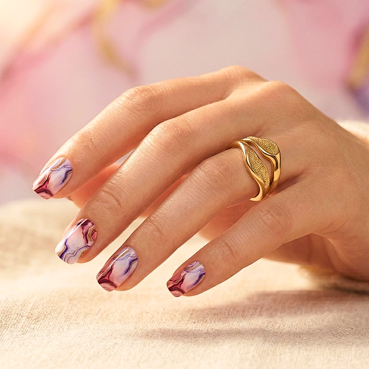 Pink and purple marble-effect nail wraps with gold veining, glossy finish