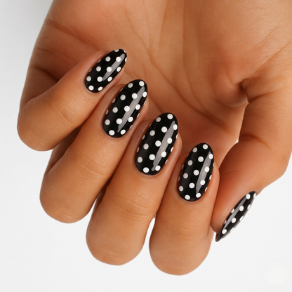 Glossy black nail wraps with white polka dot pattern, almond shape