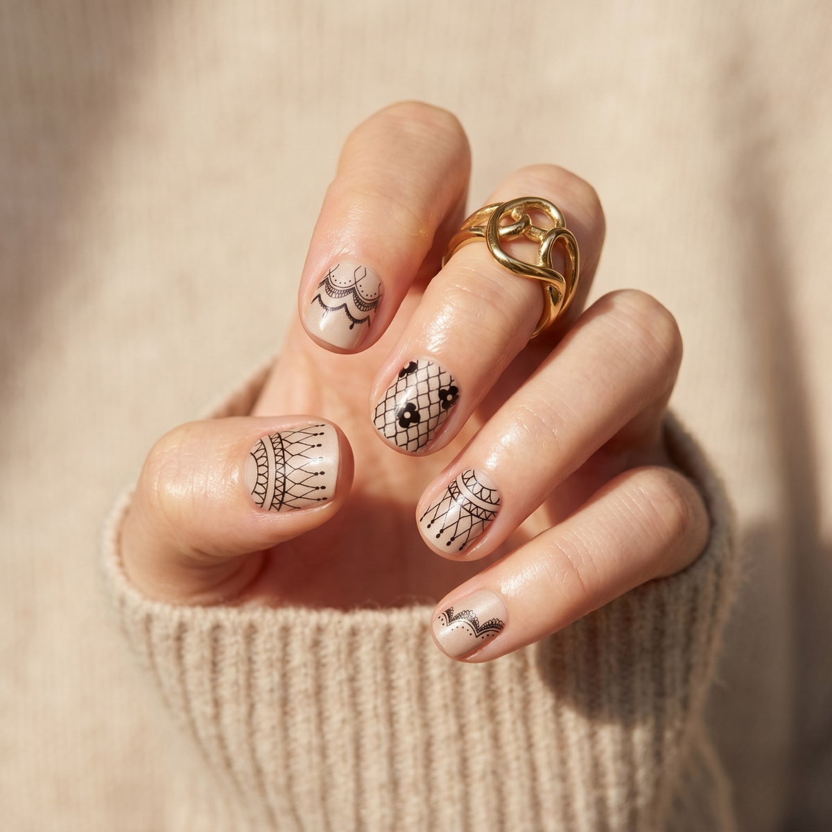 Nude nail wraps with black lace-style floral and fishnet line art designs