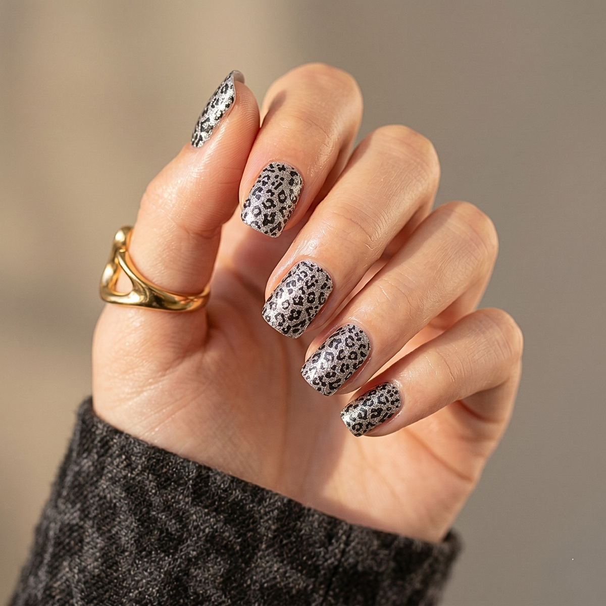 Silver metallic nail wraps with black leopard print pattern, glossy finish on short round nails.
