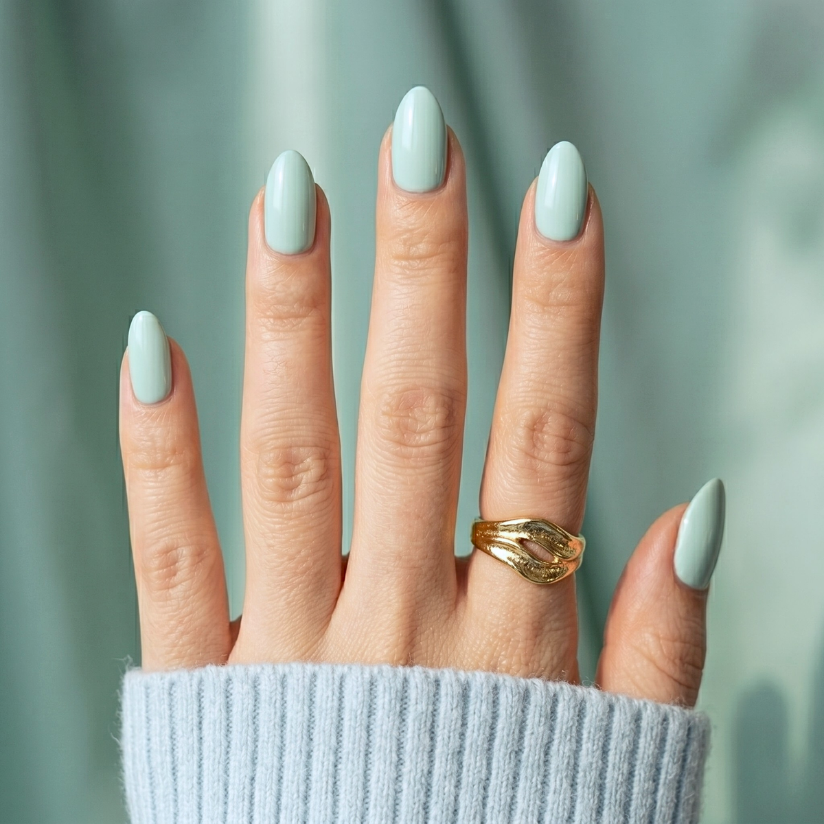 Sage green glossy soft gel press-on nails in a short oval shape, solid colour finish.