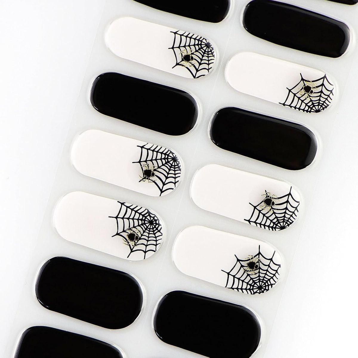 Semi-cured gel nail wraps, glossy black and white with black spiderweb and spider Halloween design.