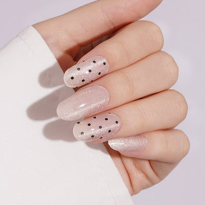 Shimmery nude pink semi-cured gel wraps with black polka dot accents, glossy finish