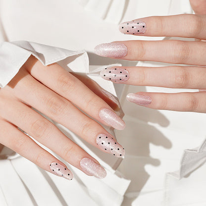 Pink shimmer semi-cured gel nail wraps with scattered black polka dot accents