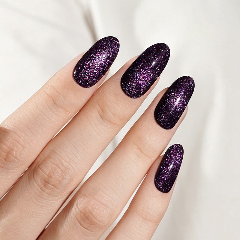 Deep purple cat's-eye shimmer semi-cured gel nail wraps on an almond shape.