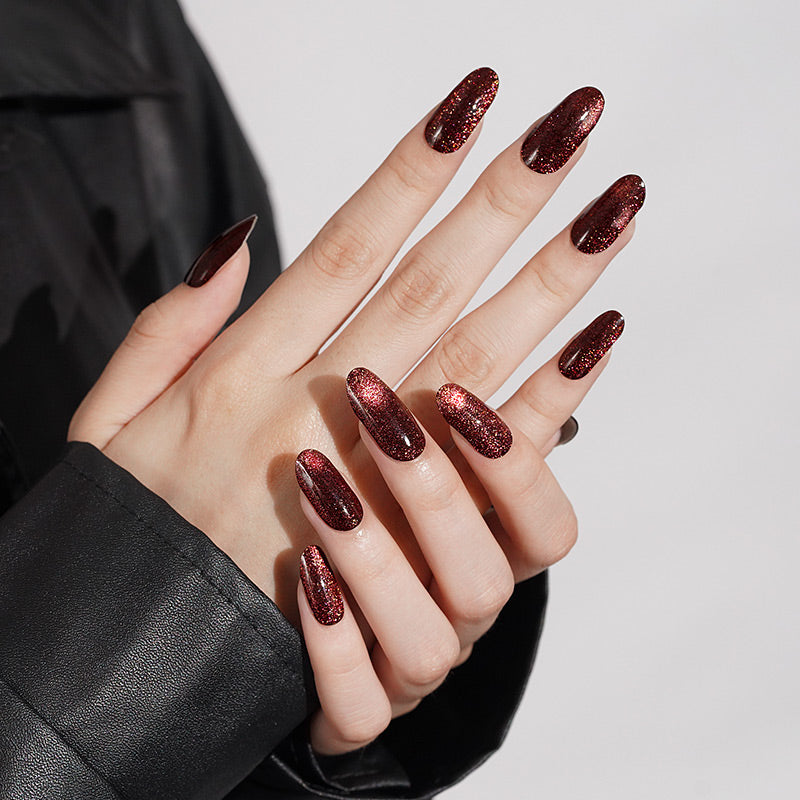 Deep burgundy cat's eye shimmer semi-cured gel nail wraps on almond-shaped nails
