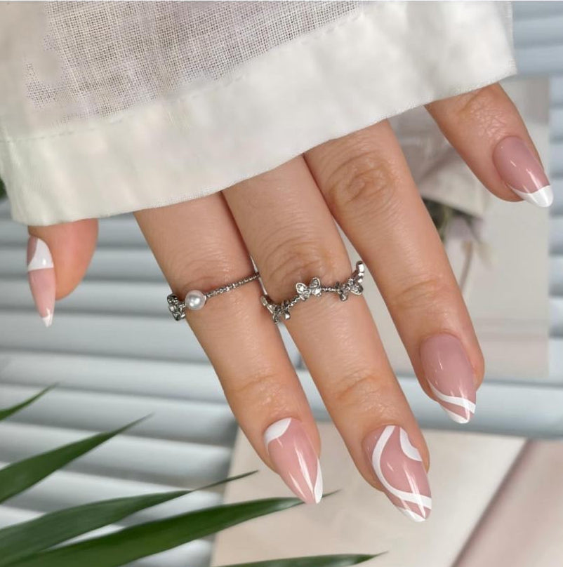 Glossy nude press-on nails with abstract white swirl French tip design