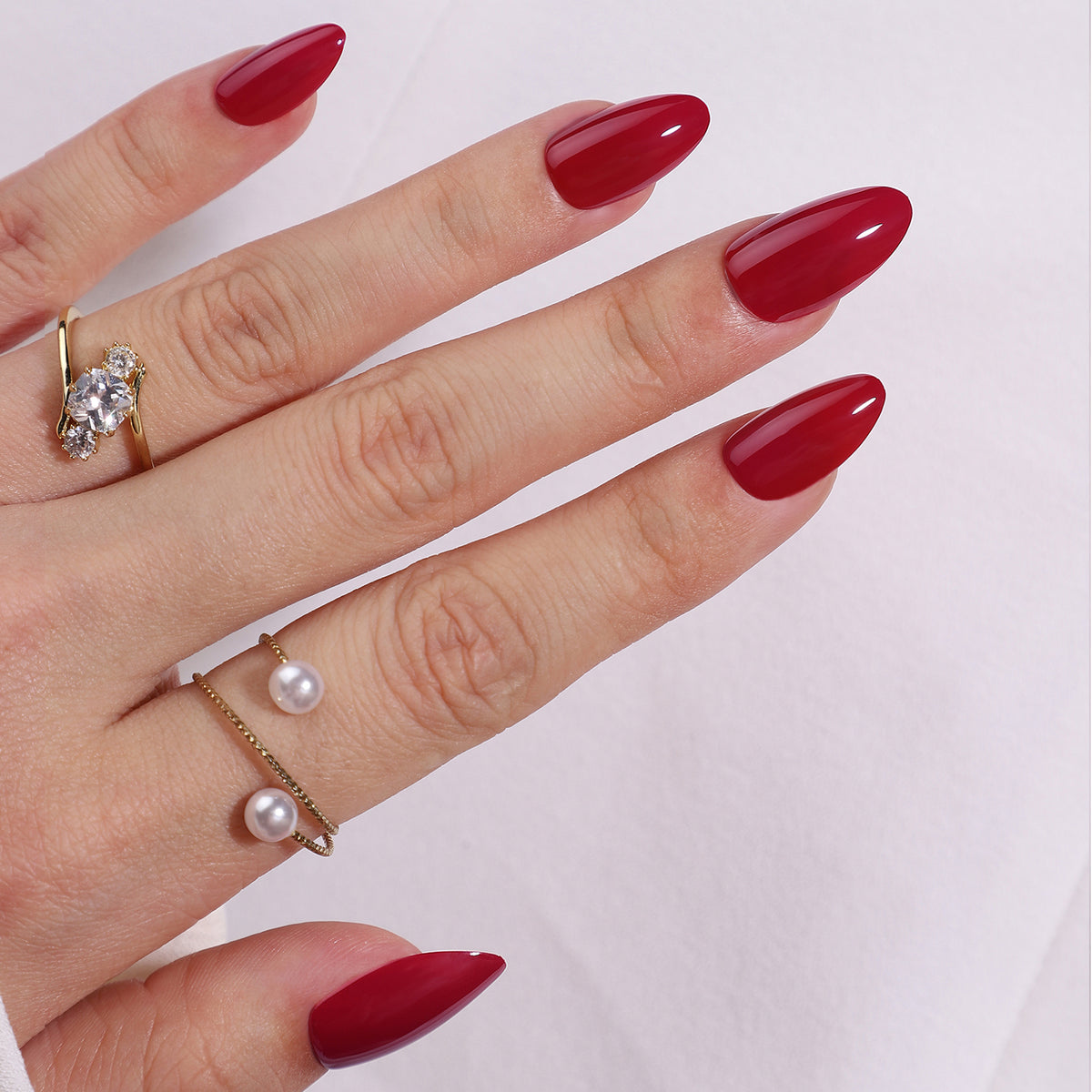 Deep red glossy soft gel press-on nails in a short almond shape