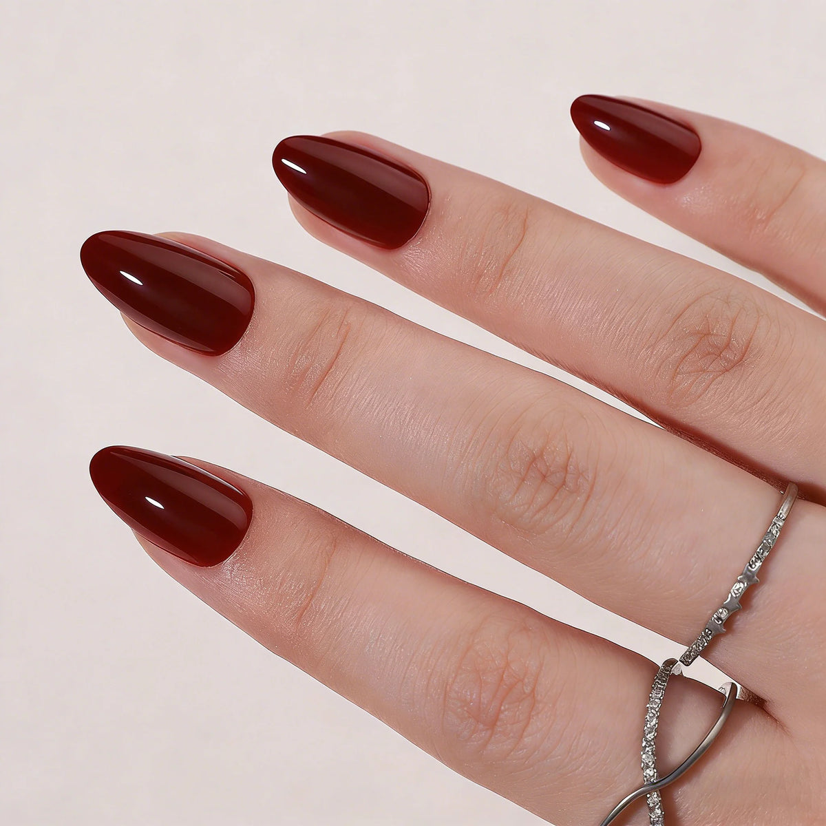 Dark burgundy glossy soft gel press-on nails in a short almond shape