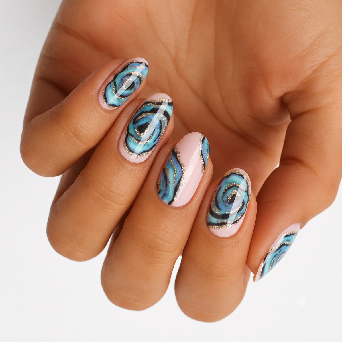 Blue-green abalone shell nail wraps with gold shimmer accents on nude base