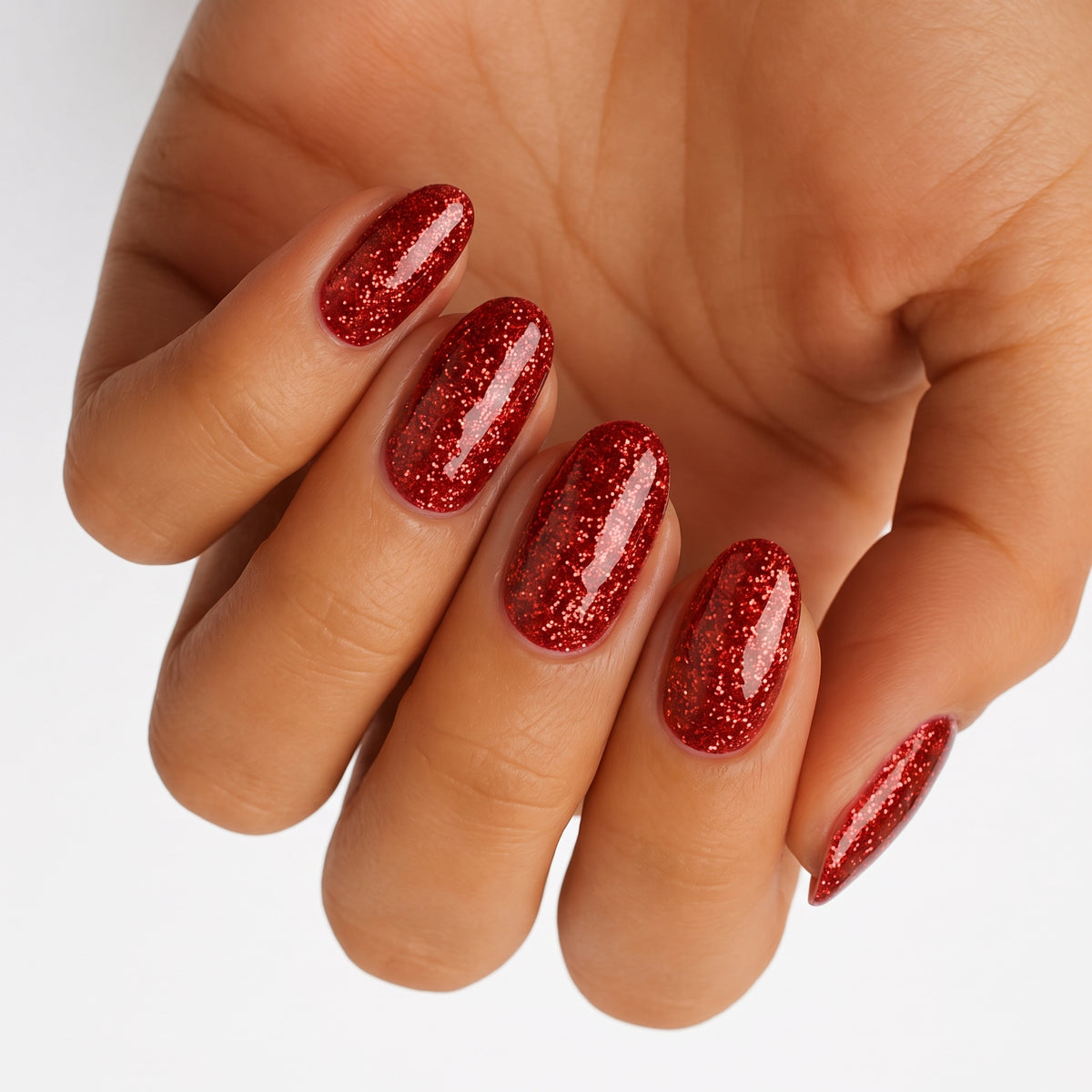 Glossy red glitter nail wraps on almond-shaped nails, sparkling crimson finish