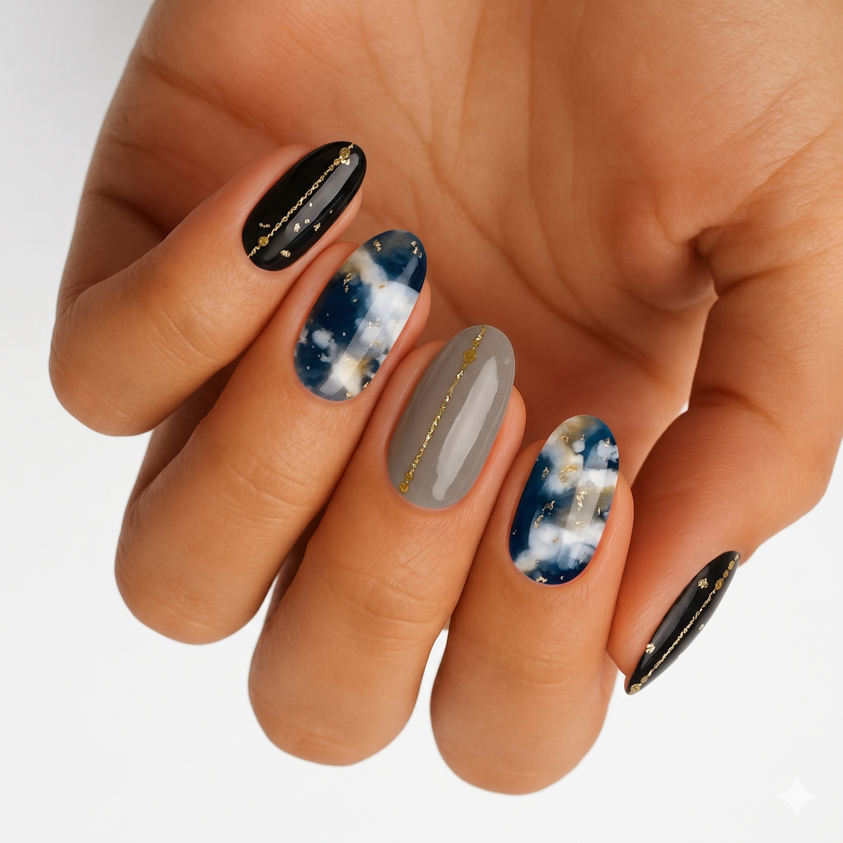 Black, navy cloud-print, and taupe nail wraps with gold foil chain accents