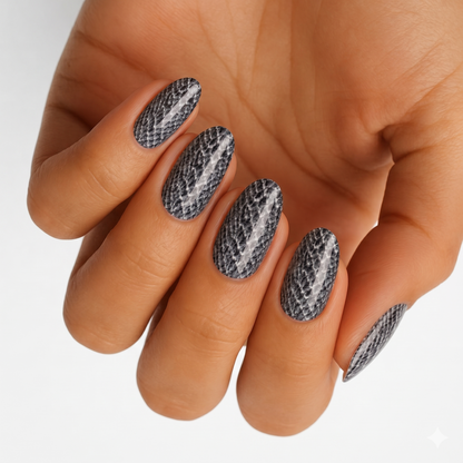 Grey and black snakeskin print nail wraps on almond-shaped nails.