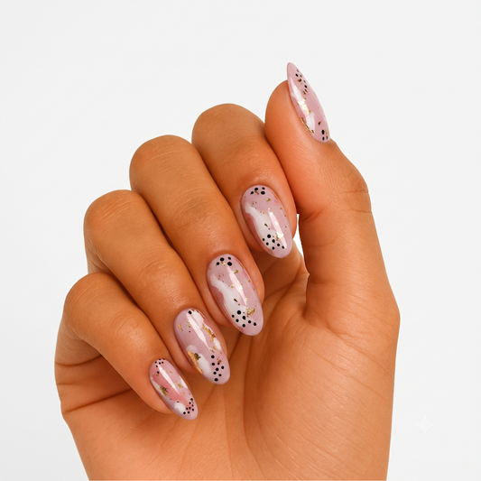 Mauve pink nail wraps with white marbling, gold foil flecks, and black dot accents