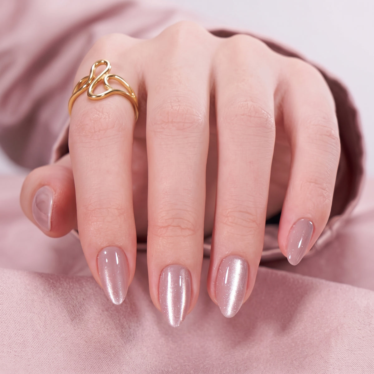 Soft gel press-ons in shimmering mauve-pink with a glossy, pearlescent finish on short almond nails