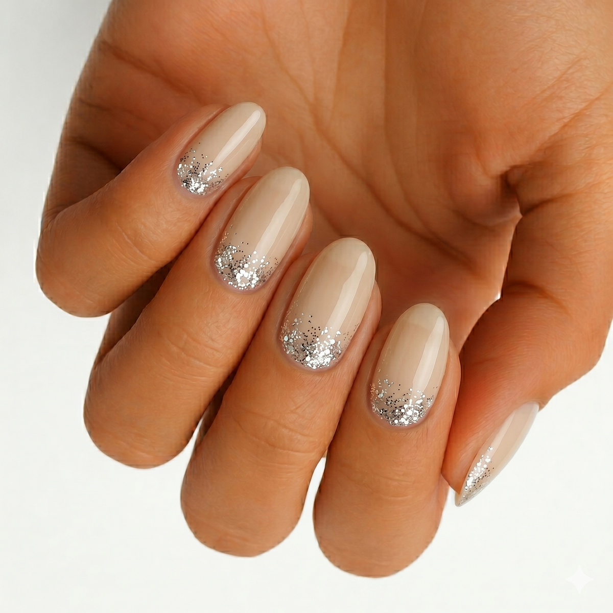 Nude glossy nail wraps with silver chunky glitter gradient at the cuffs, oval shape
