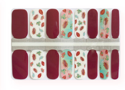 Burgundy nail wraps with autumn leaf print accents in pink, mint, and cream tones.