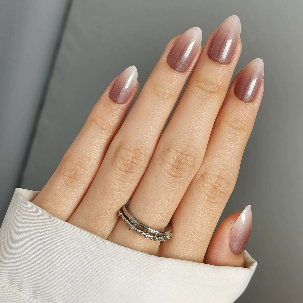 Short almond soft gel press-ons with glossy mauve-brown ombre fading into sheer nude base.