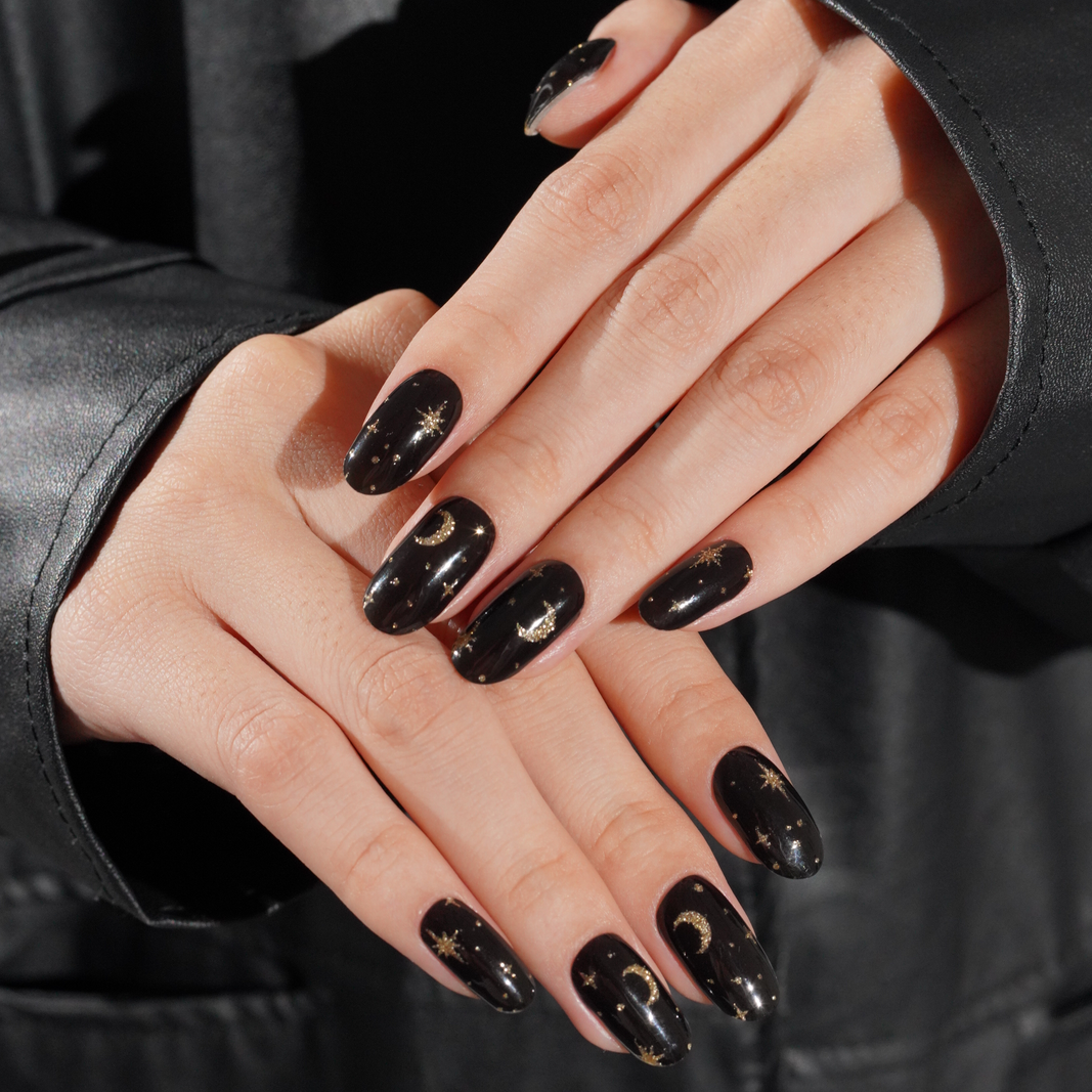 Black glossy semi-cured gel nail wraps with gold celestial moon and star design
