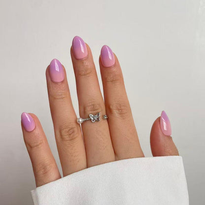 Glossy press-on nails with lilac-to-pink ombré gradient on almond-shaped tips