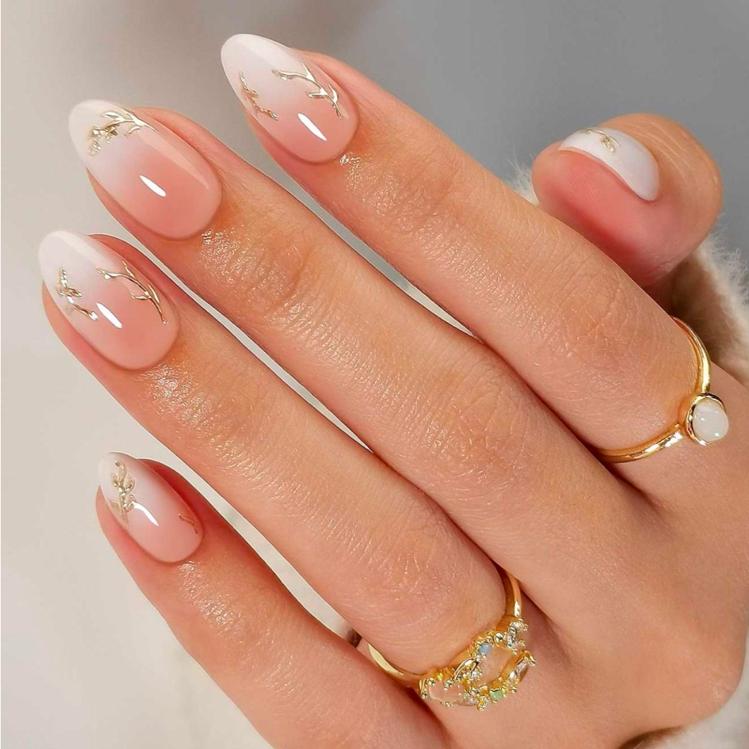 Glossy nude press-on nails with white French tips and gold branch accents