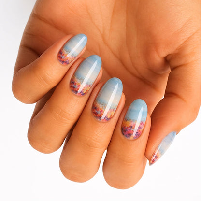 Glossy nail wraps with blue sky ombré fading into a multicolour wildflower field base