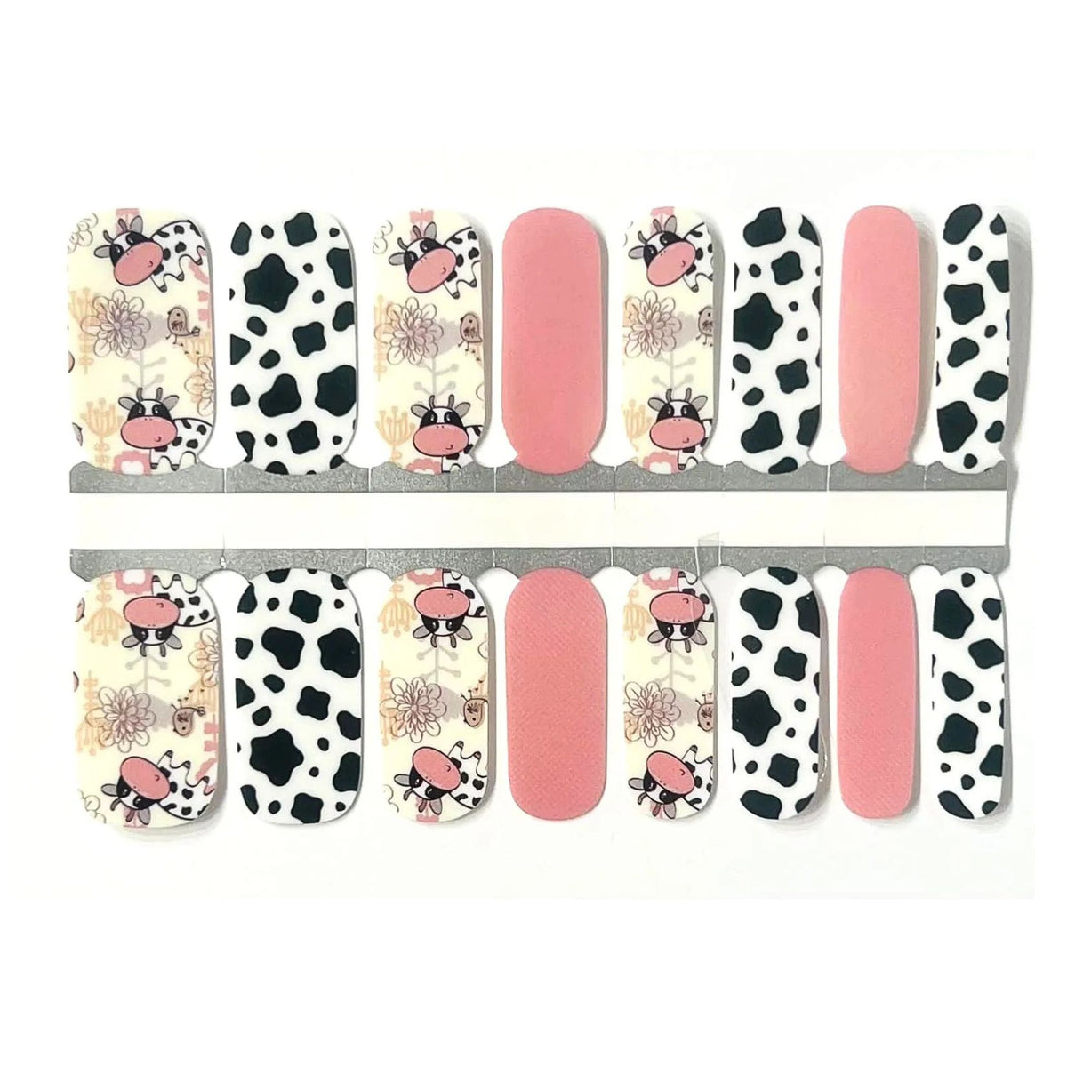 Nail wraps with cartoon cow print, black-and-white cow spots, and solid pink accent nails.
