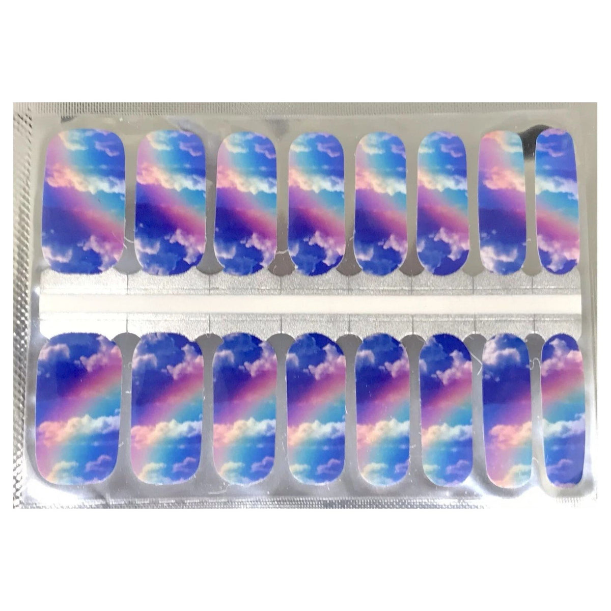 Nail wraps with blue sky, clouds and pastel rainbow design across nails