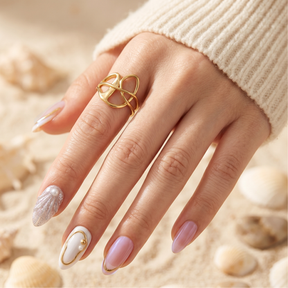 Press-on nails with pearlescent nude tones, glitter shell and pearl accents on almond shape
