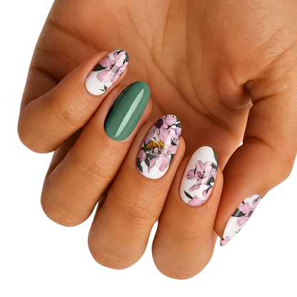 Nail wraps with white and green base, pink floral print and bee accent detail