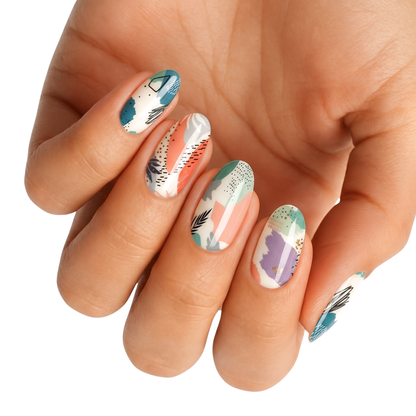Nail wraps with abstract teal, coral, and lavender geometric shapes on white base