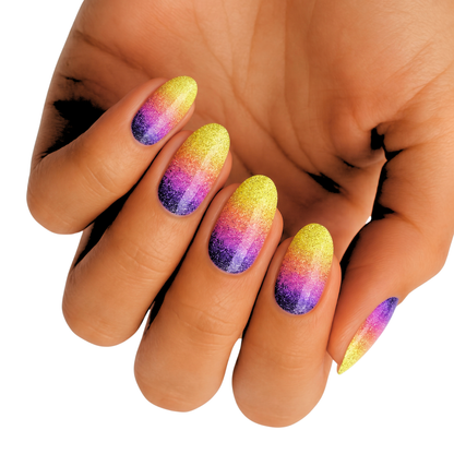 Glittery nail wraps with yellow-to-pink-to-purple ombré on almond-shaped nails