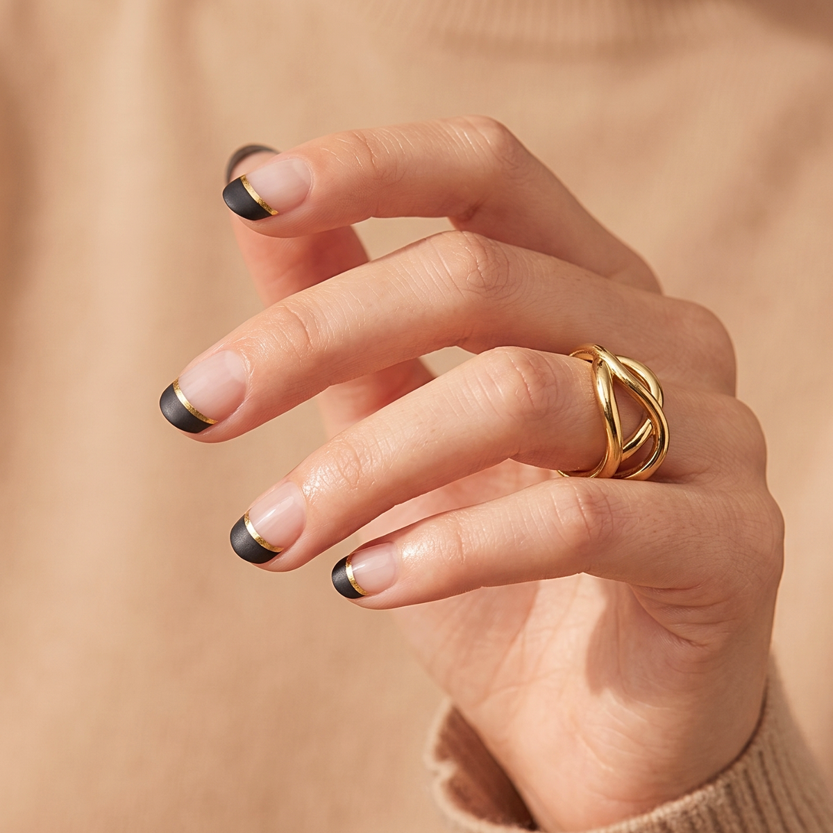 Nail wraps with sheer base, black French tips and thin gold line accent