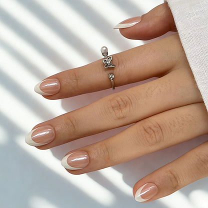 Soft gel press-ons, extra short round, nude nails with glossy diagonal white French tips.