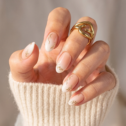 Sheer nude soft gel press-ons with white tips and delicate gold willow branch design