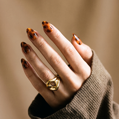 Almond soft gel press-on nails in glossy amber tortoiseshell pattern, extra short length.