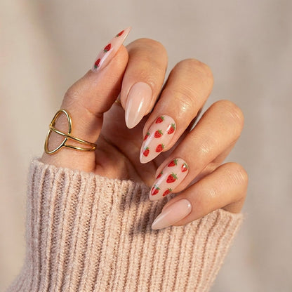 Sheer nude glossy press-on nails with red strawberry print, almond shape