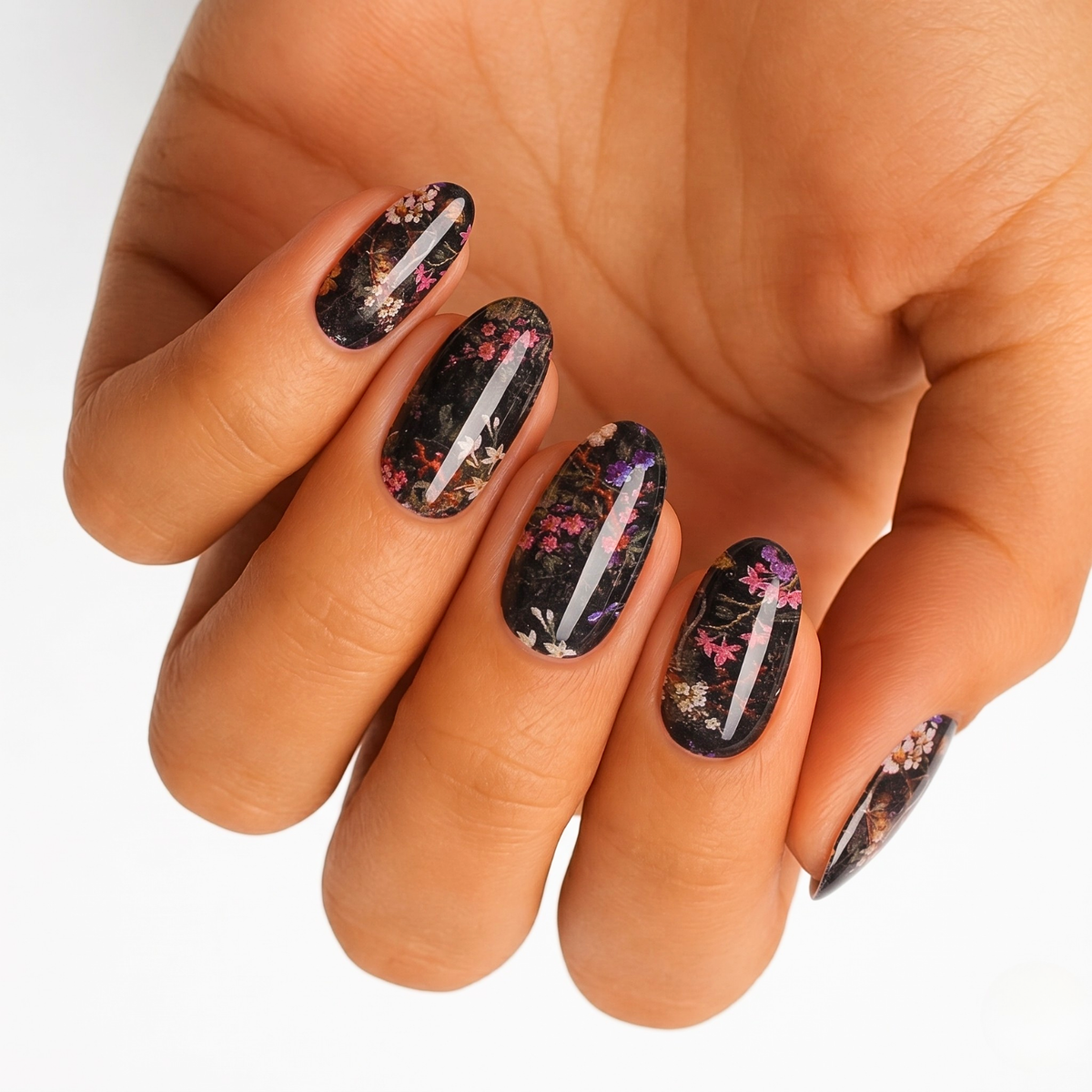 Black nail wraps with pink and purple floral branch design and glossy foil accents