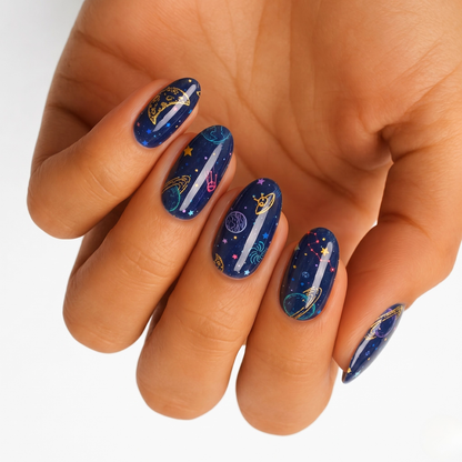 Navy blue nail wraps with glossy finish, featuring gold moons, planets and stars
