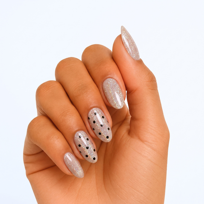 Sheer glittery nude semi-cured gel wraps with black polka dot accents, glossy finish