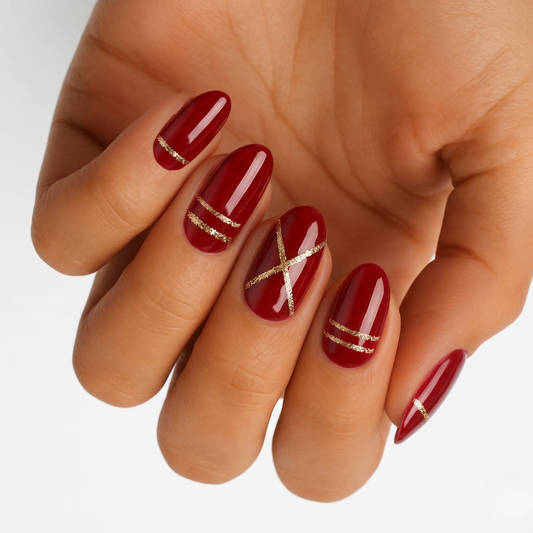 Glossy deep red nail wraps with gold glitter line and X accent details