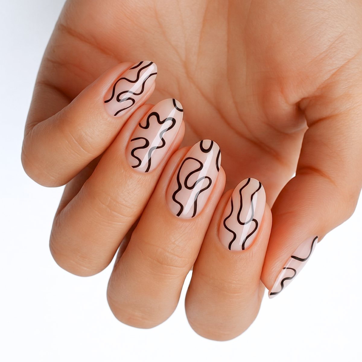Sheer nude nail wraps with abstract black squiggly line art, glossy finish