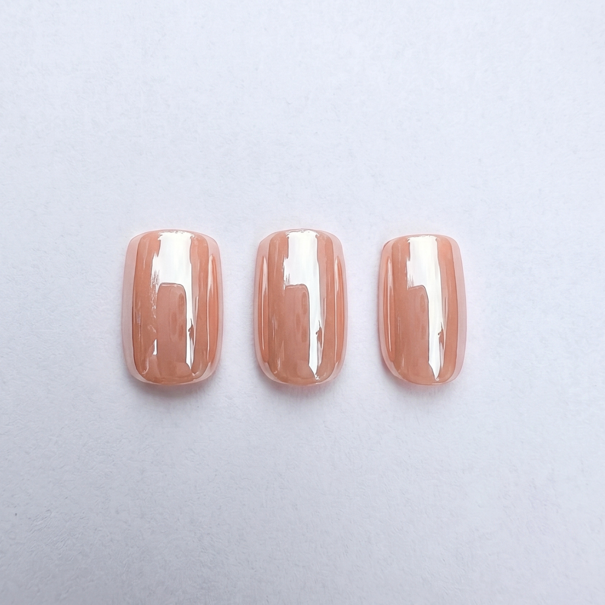 Short square soft gel press-on nails in glossy translucent peach-nude