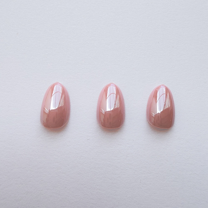 Glossy dusty pink soft gel press-on nails in a short rounded almond shape