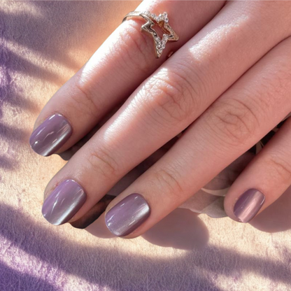 Soft gel press-ons in dusty mauve-purple with shimmering cat's eye finish, extra short natural shape