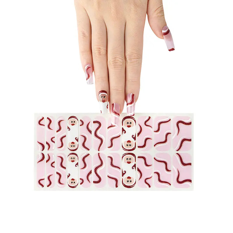 Nail wraps with pink glittery swirls and cartoon Santa faces on white base